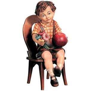 Bub sitzend mit Ball und Blume und Stuhl